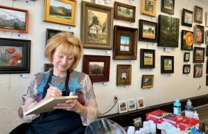 Artist Charlotte Wright paints in the Midway Art Association Gallery